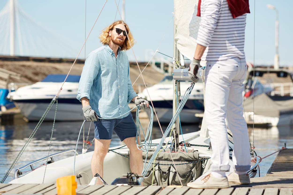 young-man-fixing-rope-on-sail-boat
